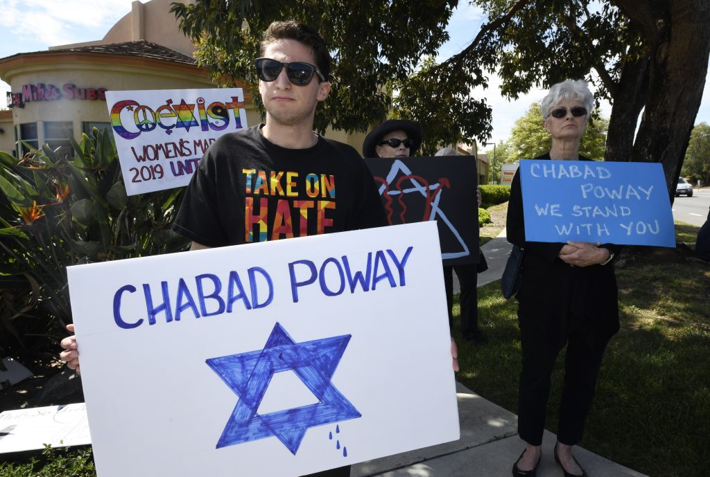 Synagogue Shooting-California People gathering on a street corner hold signs in support of the victims of Saturday's shooting at Chabad of Poway synagogue, Sunday, April 28, 2019, in Poway, Calif. A man opened fire Saturday inside the synagogue near San Diego as worshippers celebrated the last day of a major Jewish holiday. (AP Photo/Denis Poroy)