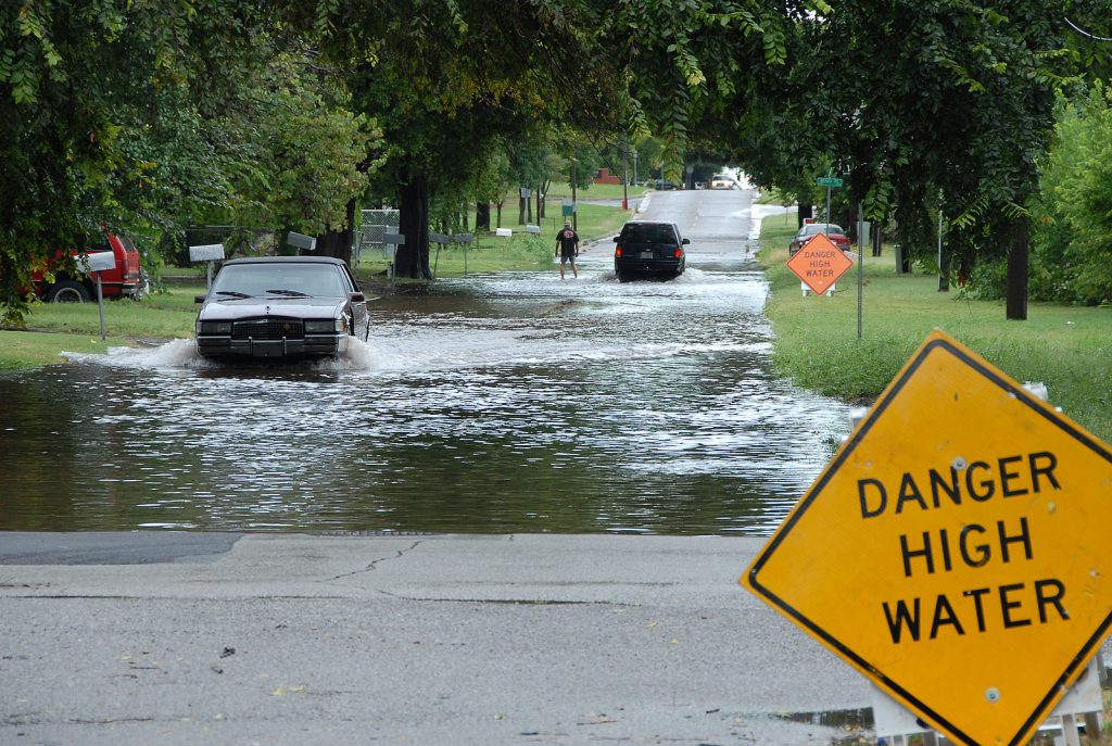 FEMA_-_32096_-_Cars_drives_though_flooded_street_in_an_Oklahoma_neighborhood Car driving through a flooded street. (FEMA)