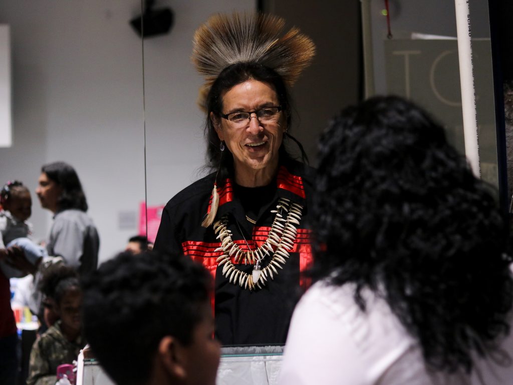 SEEDS10 Tchin, an internationally showcased jewelry maker who lives in New Jersey, speaks with visitors at the We Are the Seeds festival (Angela Gervasi for WHYY)
