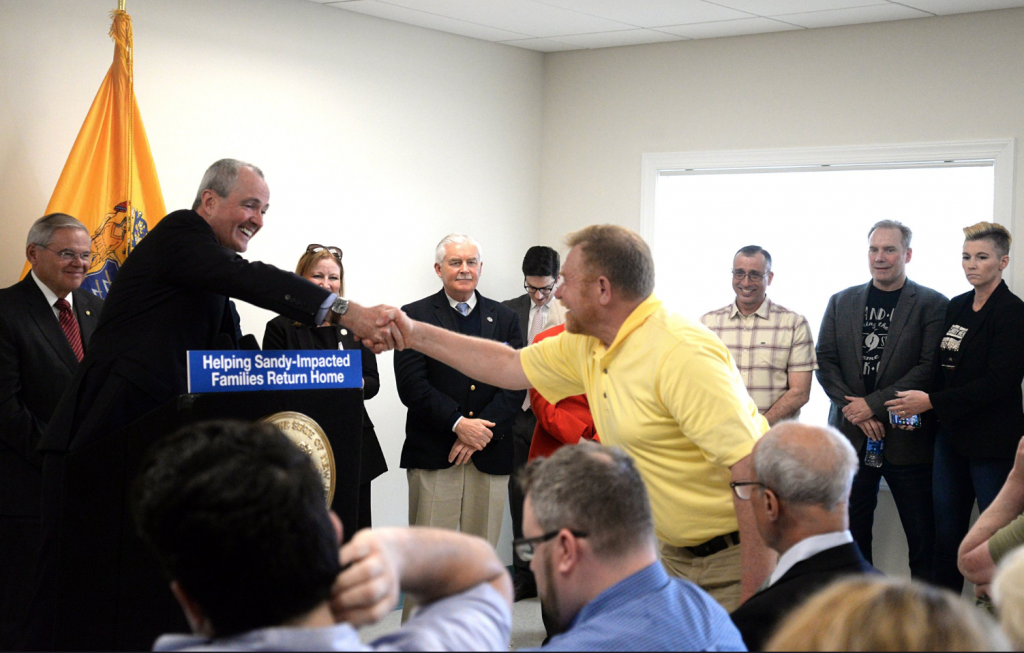 Screen Shot 2019-04-08 at 2.14.43 PM New Jersey Gov. Phil Murphy shakes the hand of a man at a press conference Monday at the Shark River Municipal Marina in Neptune Township. (Image: N.J Office of the Governor)
