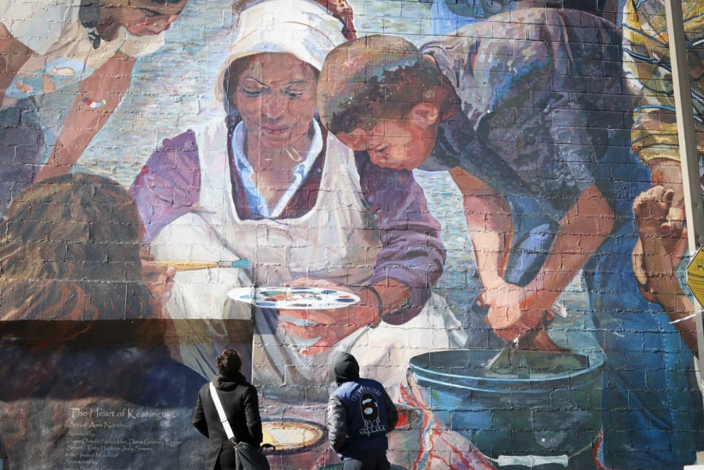 Screen Shot 2019-04-11 at 2.53.39 PM Awilda Ocasio’s sons Edgardo Colón (left) and Marco López look up at Ann Northrup’s “Heart of Kensington” mural at Kensington and Allegheny Avenues on Feb. 25, 2019. Ocasio is pictured at the center of the mural surrounded by children. (Solmaira Valerio/Kensington Voice)