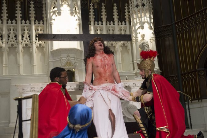 Centurions, played by Mark Samani and Radick Hastings, strip Jesus of his garments at the 10th Station of the Cross. (Jonathan Wilson for WHYY)