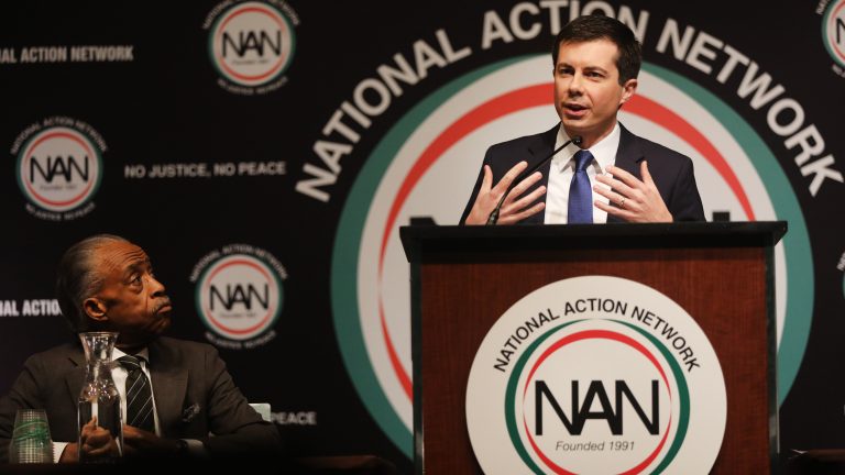 With the Rev. Al Sharpton looking on, Democratic presidential hopeful South Bend, Ind., Mayor Pete Buttigieg speaks at the National Action Network's annual convention Friday in New York City. (Spencer Platt/Getty Images)