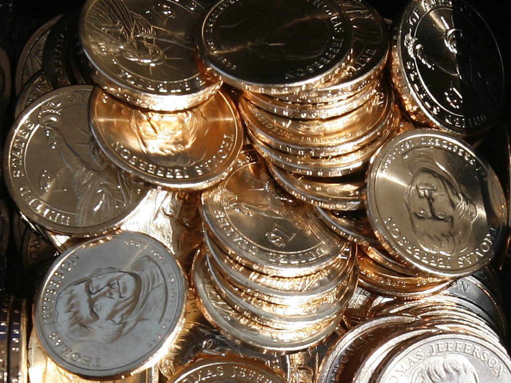 A pile of newly minted one-dollar coins honoring former Thomas Jefferson are seen at the unveiling by the U.S. Mint in Washington, D.C., in 2007. In a turnaround, congressional analysts are no longer recommending a phaseout of paper dollars in favor a dollar coin. (Jim Young/Reuters)