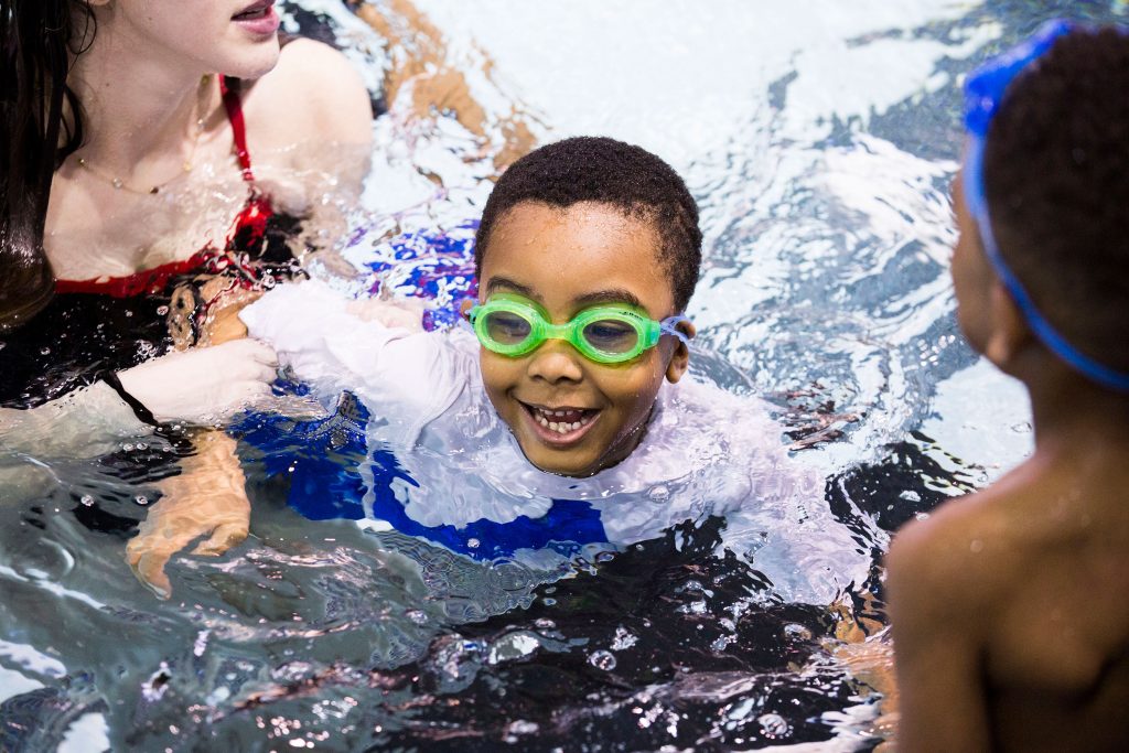 2019-03-23—r-wisniewski—Natalie-Edman-Quintin-Whitner–University-of-Pennsylvania—We-Can-Swim-rs Natalie Edman (left), a freshman at the University of Pennsylvania, gives Quintin Whitner, 6 (center), a swimming lesson through We Can Swim on March 23, 2019. (Rachel Wisniewski for WHYY)