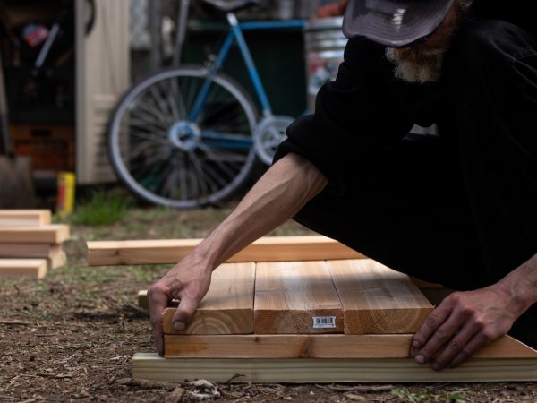 After waiting for a Saturday lumber delivery, volunteers begin laying the framework for garden beds. (Angela Gervasi for WHYY)