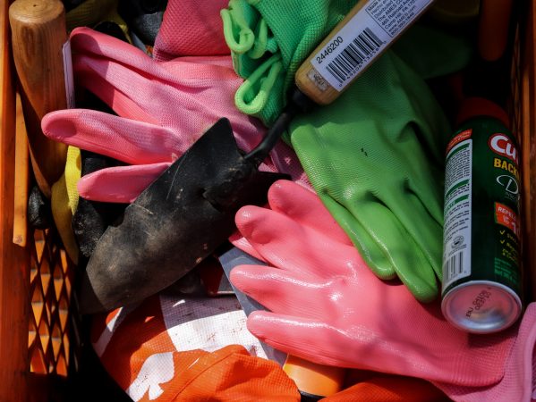 Gloves, gardening tools and insect repellent await volunteers at a new garden on Jefferson and Orkney streets in Kensington. (Angela Gervasi for WHYY)