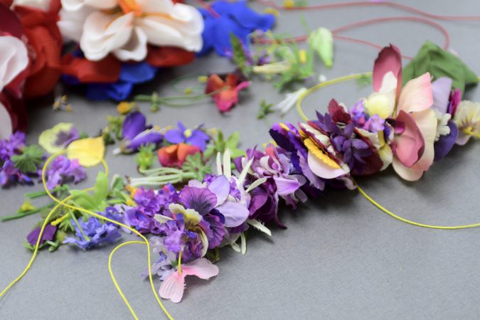 Shamirah Brown, 18 strings together (fake) flowers to be used as decoration for the opening of new horticulture center for students who are blind, visually impaired or have other disabilities at the Overbrook School of the Blind, on Tuesday. (Bastiaan Slabbers for WHYY)