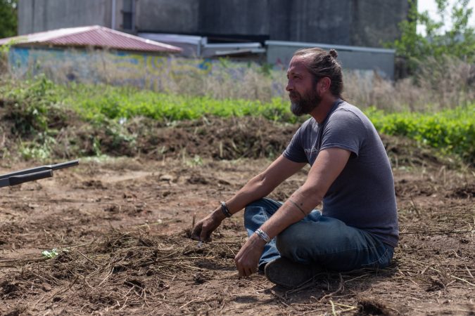 Volunteer John Mulligan observes the growth of the César Andreu Iglesias Community Garden. (Angela Gervasi for WHYY)