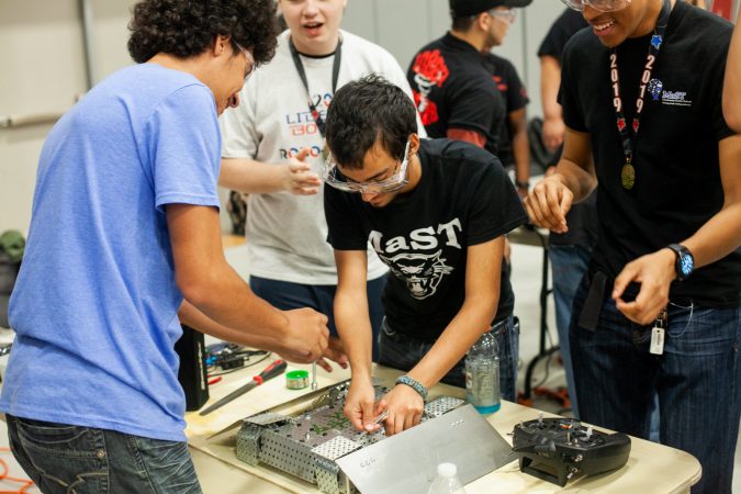Students from MaST Community Charter School work on their robot Mcnasty between rounds at the Liberty Bots competition Saturday at Montgomery County Community College. (Brad Larrison for WHYY)