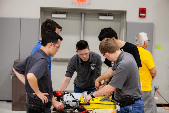 Students from Upper Bucks County Technical School work on their robot Pre-Swiss Cheese between rounds at the Liberty Bots competition Saturday at Montgomery County Community College. (Brad Larrison for WHYY)