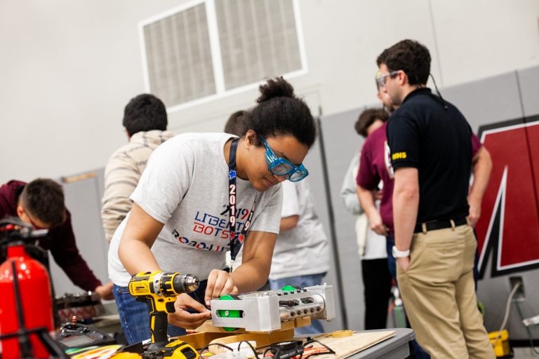 Ashley Yates of Harry S. Truman High School works on her team's robot between rounds at the Liberty Bots competition Saturday at Montgomery County Community College. (Brad Larrison for WHYY)