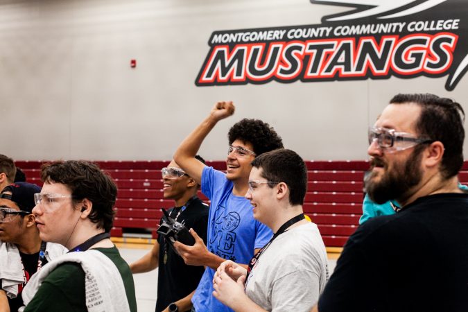 Students from MaST Community Charter School celebrate a victory over Trenton High School Saturday during the Liberty Bots competition Montgomery County Community College. (Brad Larrison for WHYY)