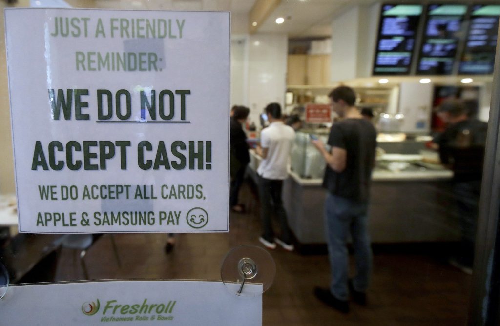 San Francisco Cashless Stores This Thursday, May 2, 2019, photo shows a sign posted on a door alerting customers that cash is not accepted at Freshroll Vietnamese Rolls and Bowls in San Francisco. San Francisco now requires brick-and-mortar retailers to take cash in payment for goods, joining Philadelphia and New Jersey in banning a practice that critics say discriminates against the poor. (Jeff Chiu/AP Photo)