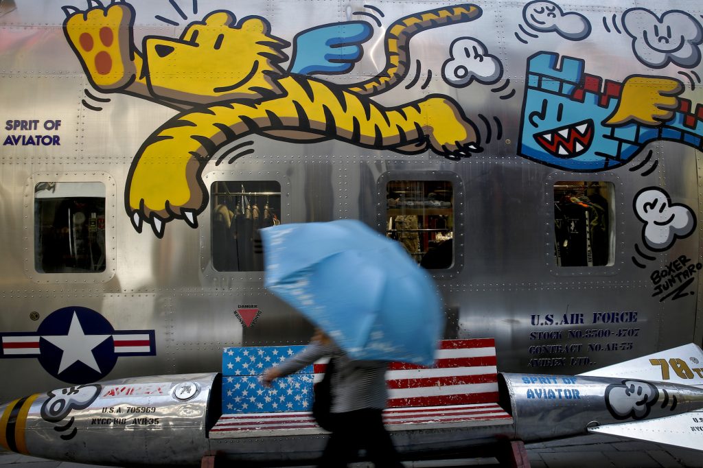 Trump China Tariffs A woman walks by a bench painted with an American flag outside a fashion boutique selling U.S. brand clothing at the capital city's popular shopping mall in Beijing, Monday, May 13, 2019. Companies waited Monday to see how China decides to retaliate for President Donald Trump’s latest tariff hike while forecasters warned their escalating fight over technology and trade might disrupt a Chinese economic recovery. (Andy Wong/AP Photo)