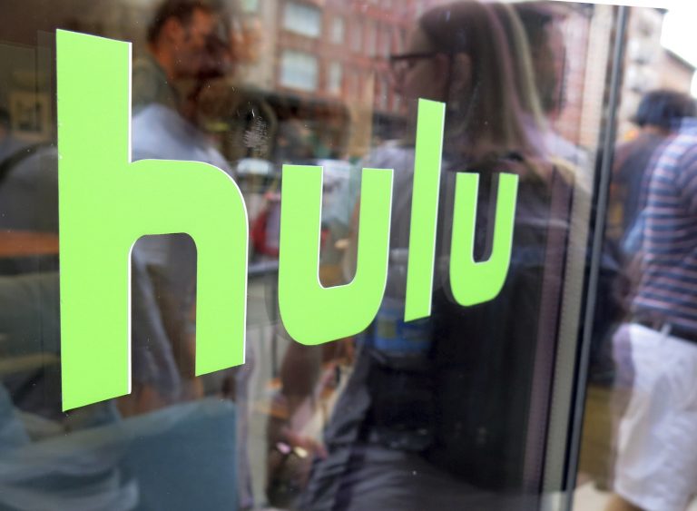 This June 27, 2015, file photo, shows the Hulu logo on a window at the Milk Studios space in New York. Disney has struck a deal with Comcast that gives it full control of streaming service Hulu. The companies said Tuesday, May 14, 2019, that as early as January 2024 Comcast can require Disney to buy NBCUniversal’s 33% interest in Hulu and Disney can require NBCUniversal to sell that stake to Disney for its fair market value at that future time. (Dan Goodman/AP Photo)