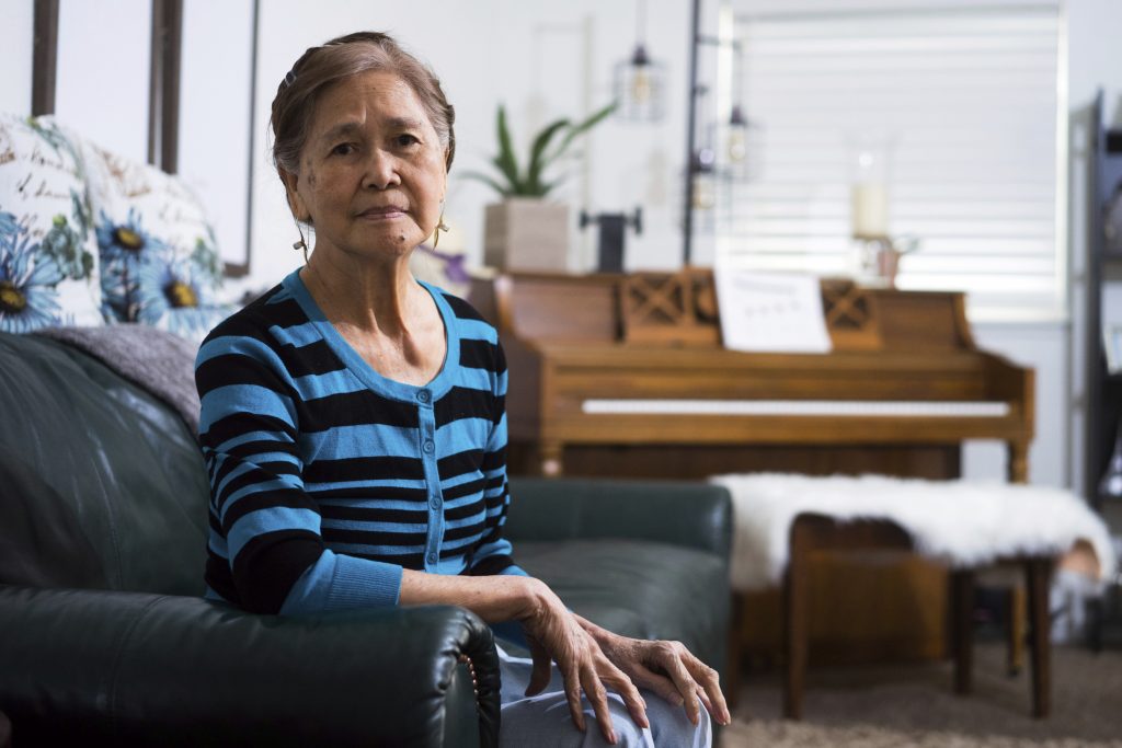 Residential Care Normita Lim poses for a photograph at her home in Concord, Calif. Lim did not receive back pay from her former employer, Publico, who paid her $2 an hour. (James Tensuan/Reveal via AP)
