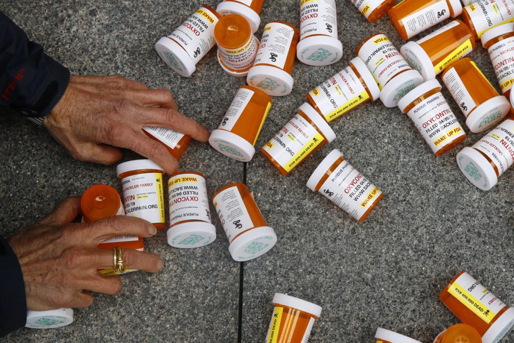 Global Opioids Italy Pain League Top Takeaways In this Friday, April 5, 2019, file photo, a protester gathers containers that look like OxyContin bottles at an anti-opioid demonstration in front of the U.S. Department of Health and Human Services headquarters in Washington, D.C. (Patrick Semansky/AP Photo)