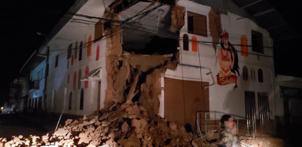 Peru Earthquake In this photo provided by Firefighters of Peru, people pass in front destroyed wall in Yurimaguas Peru, Sunday, May 26, 2019. A powerful magnitude 8.0 earthquake struck the Amazon jungle in north-central Peru early Sunday, the U.S. Geological survey reported, collapsing buildings and knocking out power to some areas. (Firefighters of Peru via AP)
