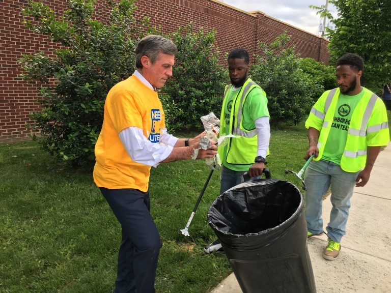 Gov. John Carney picks up litter along Vandever Ave. in northeast Wilmington. (Mark Eichmann/WHYY)
