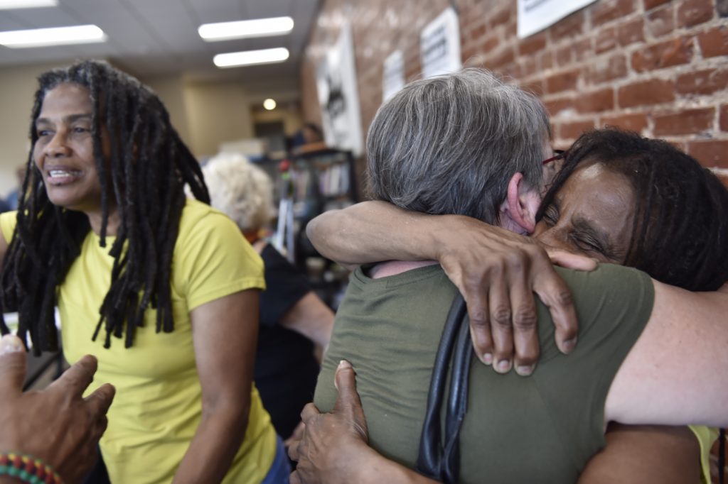 Image-2 Janet Africa (right) embraces Betsy Piet while on the left, Janine Africa greets a well wisher. Janet and Janine Africa were recently released after serving 40 years in prison for their role in the shooting death of a police officer. (Jonathan Wilson for WHYY)