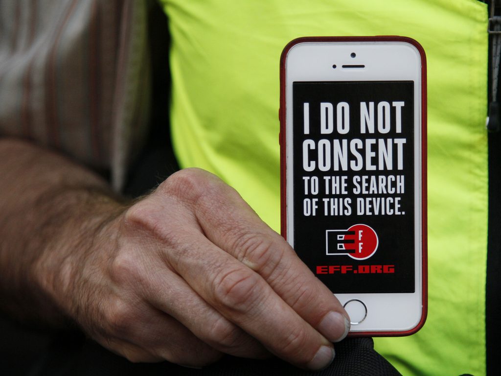 In this 2016 photo, a man holds up his iPhone during a rally in support of data privacy outside the Apple store in San Francisco. Watchdog groups that keep tabs on digital privacy rights are concerned that U.S. Customs and Border Protection agents are searching the phones and other digital devices of international travelers at border checkpoints in U.S. airports. In this 2016 photo, a man holds up his iPhone during a rally in support of data privacy outside the Apple store in San Francisco. Watchdog groups that keep tabs on digital privacy rights are concerned that U.S. Customs and Border Protection agents are searching the phones and other digital devices of international travelers at border checkpoints in U.S. airports. (Eric Risberg/AP)