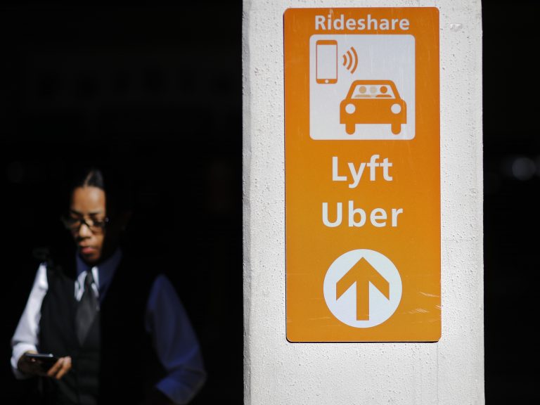 A sign directs Lyft and Uber riders to a designated pickup location at Hartsfield-Jackson Atlanta International Airport in Atlanta. (David Goldman/AP Photo)