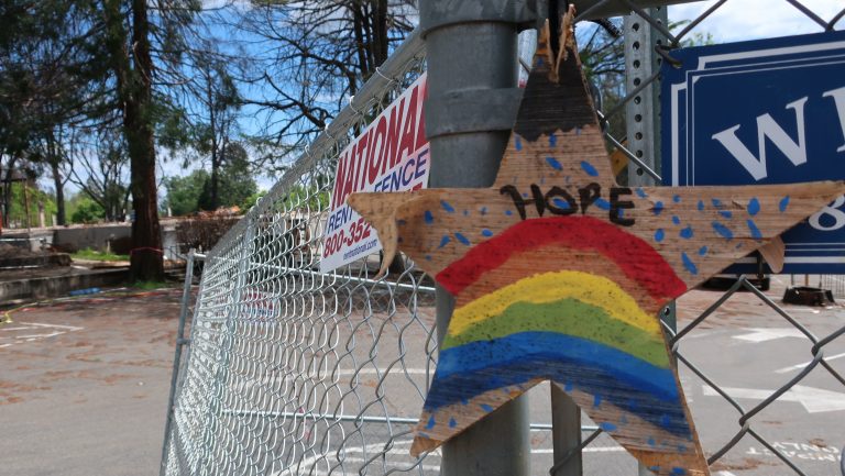 A homemade sign hangs on the fence surrounded Paradise Elementary School. The school was destroyed by the fire and the rubble is now being bulldozed and cleaned up.
(Michelle Wiley/KQED)
