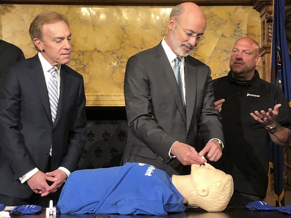 Opioids-Pennsylvania Gov. Tom Wolf listens to trainer Elvis Rosado, (right), of Philadelphia-based Prevention Point on how to administer a nasal spray that reverses an opioid overdose during a demonstration in Wolf's Capitol offices, Wednesday, May 22, 2019, in Harrisburg, Pa. Looking on is Paul Tufano, CEO of AmeriHealth Caritas, a Medicaid insurer that sponsors training. (Marc Levy/AP Photo)