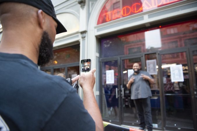 Troc staff members and fans take photos and selfies in front of the theater's entrance on the night of the last performance. (Jonathan Wilson for WHYY)
