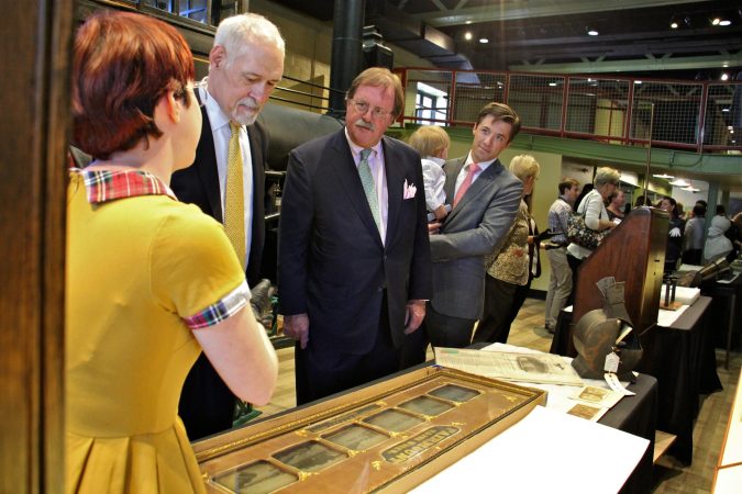Members of the Hamilton family listen as curatorial assistant Ariel McManus (left) describes items in the Franklin Institute's collection which will be displayed in the new space. (Emma Lee/WHYY)