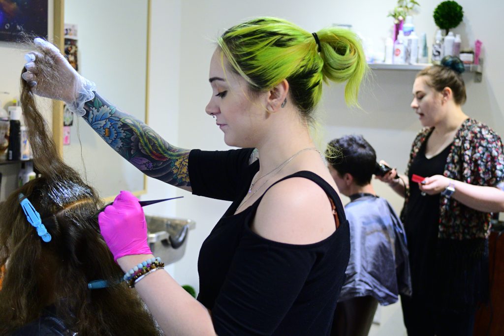 Salon Profesionals Domestic Violance Awarenes Kristina Amell and Grace Berry attend to clients at Starshine Salon, located on Manayunk's Main Street. (Bastiaan Slabbers for WHYY)