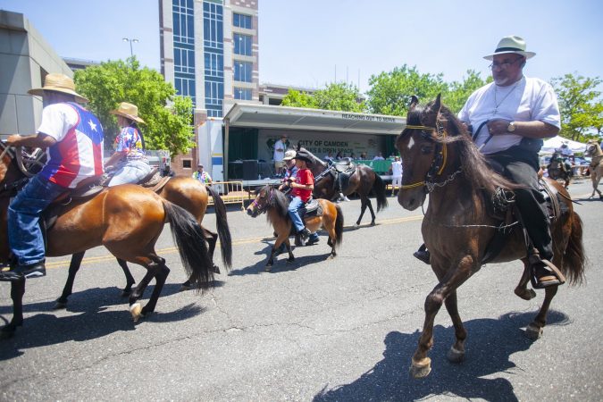 Horse riders parade through the streets of Camden during the San Juan Bautista Parade and Festival. (Miguel Martinez/WHYY)