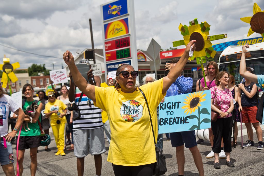 2019 06 25 k paynter refinery protest-4 Sylvia Bennett, a member of Philly Thrive, raises her arms at a protest outside Philadelphia’s PES refinery. (Kimberly Paynter/WHYY)