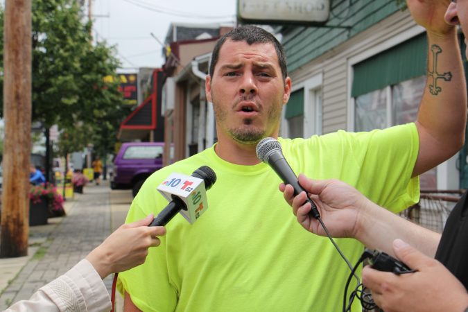 Brandon Myers talks to reporters about the flooding at his home on High Street in Westville, which forced him and his family to evacuate. (Emma Lee/WHYY)