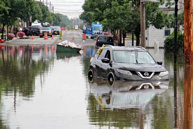 A dumpster floats among the abandoned cars on Broadway in Westville, N.J. (Emma Lee/WHYY)