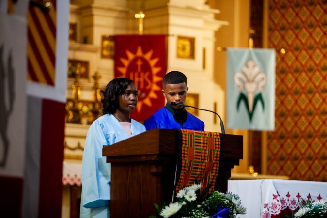 Graduating students of the Gesu School Nateerah Ransome and Alphonso Evans Jr. welcome students and parents to the school's graduation ceremony. (Brad Larrison for WHYY)