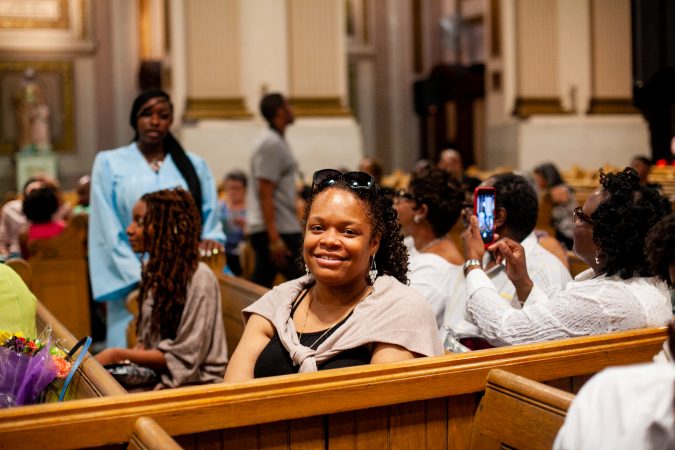 Gesu School parent Eboni Scott sits in the chapel of the Church of the Gesu before the school's graduation ceremony earlier this month. (Brad Larrison for WHYY)