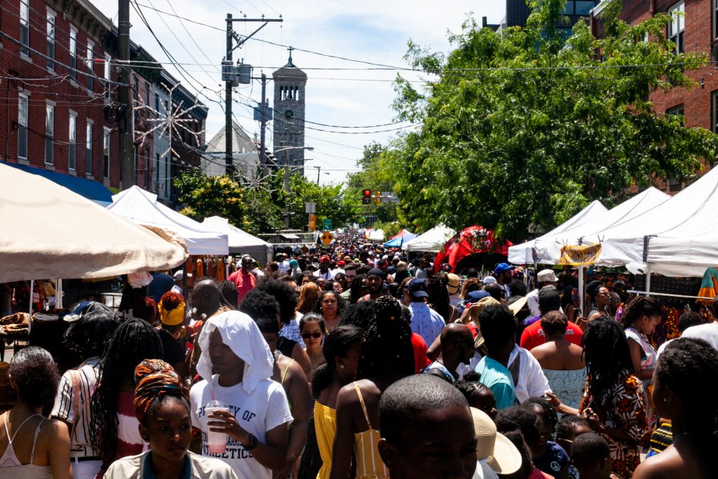 2019 6 9- b larrison- philadelphia- annual odunde festival on south street-6 People walk on a street during a street festival.