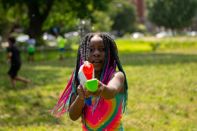 Amani Hutcherson sprays a water gun during the Water Fight Philly event on Sunday, June 30, 2019. (Kriston Jae Bethel for WHYY)