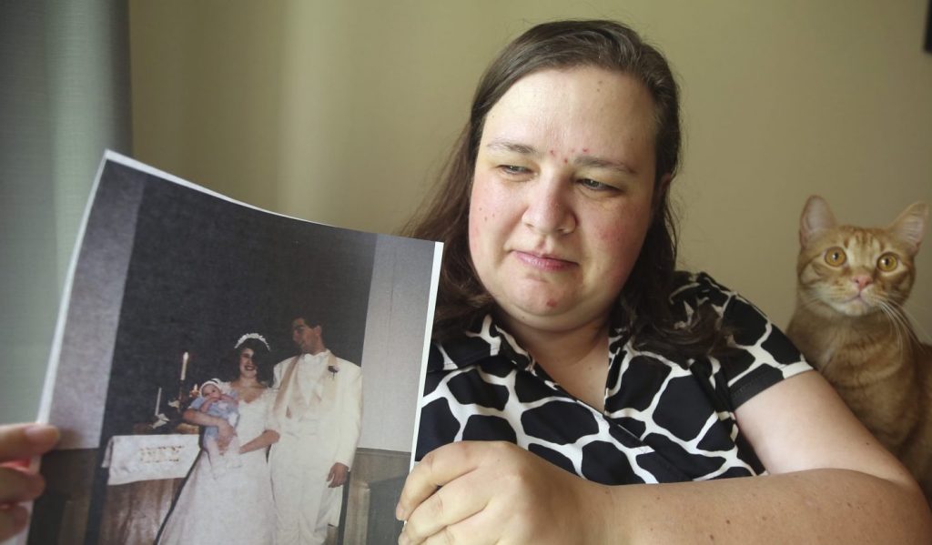 Heidi Clark holds a photograph from her 1995 wedding at her home in Orem, Utah, on Friday, May 18, 2018. Clark became pregnant at 16 and married soon after, under pressure from her boyfriend's religious community of Seventh-Day Adventists in Pennsylvania, she said. “I always felt a little bit like I was trapped,” Clark said, now 40. “I was 17. I was so young.” (Rick Bowmer/AP Photo)