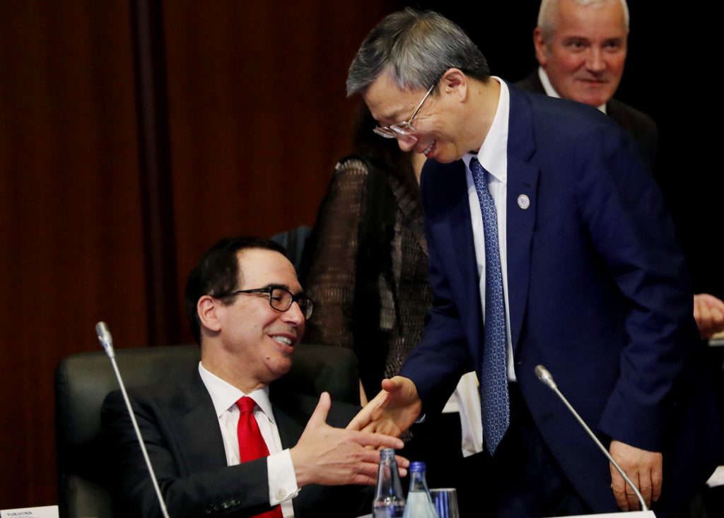 China's Central Bank Governor Yi Gang shakes hands with U.S. Treasury Secretary Steve Mnuchin, (left), during the G20 Finance Ministers and Central Bank Governors Meeting Saturday, June 8, 2019, In Fukuoka, Japan. (Kim Kyung-hoon/Pool Photo via AP)