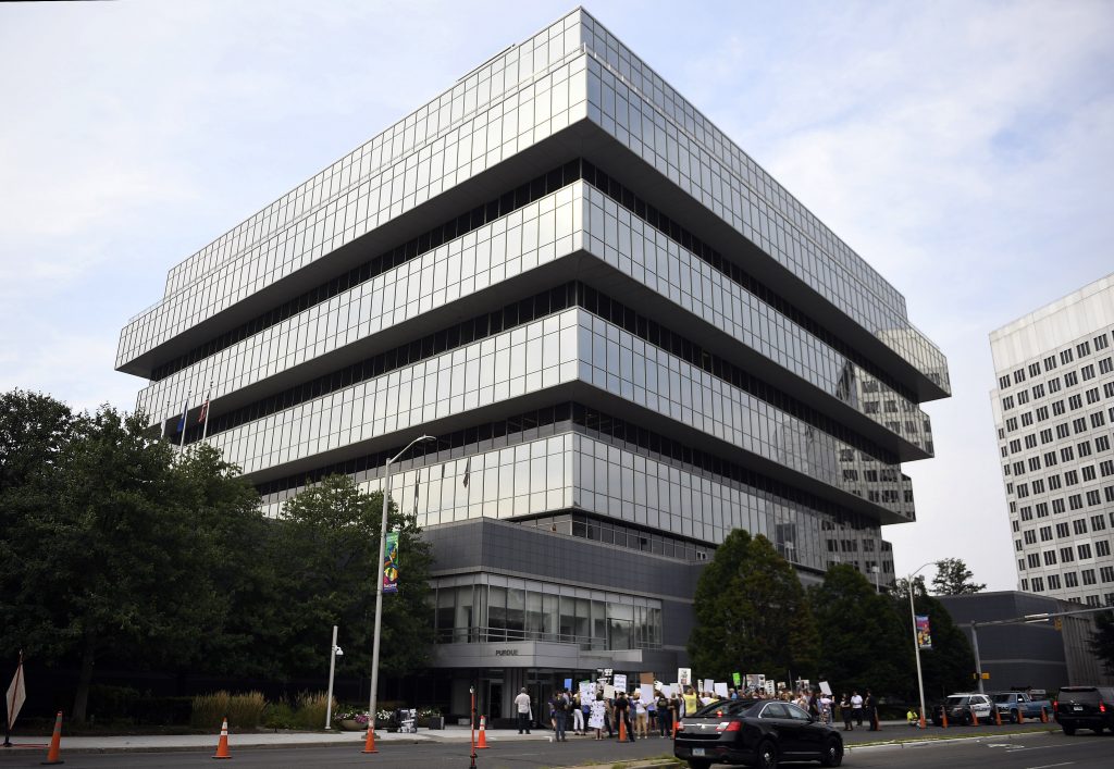 Opioid Crisis Lawsuits Connecticut In this Aug. 17, 2018 file photo, family and friends who lost loved ones to opioid overdoses protest outside the headquarters of Purdue Pharma, maker of the maker of painkiller OxyContin, in Stamford, Conn. The World Health Organization notified U.S. lawmakers Wednesday, June 19, 2019, that it will discontinue two publications on opioid painkiller prescribing, in response to allegations that the pharmaceutical industry influenced the reports. Purdue has denied the allegations. (Jessica Hill/AP Photo, file)