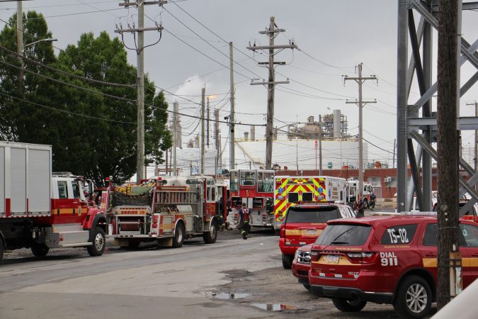 At the scene from a fire staging area under the Platt Bridge, a flare can be seen burned off fuel   (Emma Lee/WHYY)