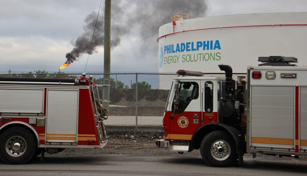 Image-uploaded-from-iOS-2-v2 At the scene from a fire staging area under the Platt Bridge, a flare can be seen burned off fuel (Emma Lee/WHYY)