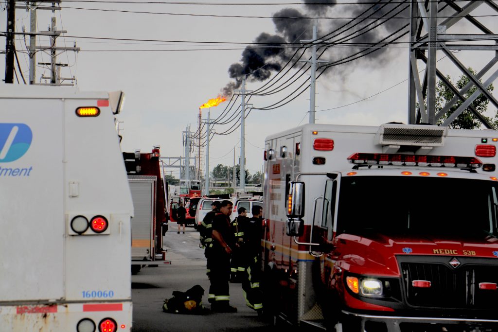 Image uploaded from iOS (3) At the scene from a fire staging area under the Platt Bridge, a flare can be seen burned off fuel (Emma Lee/WHYY)