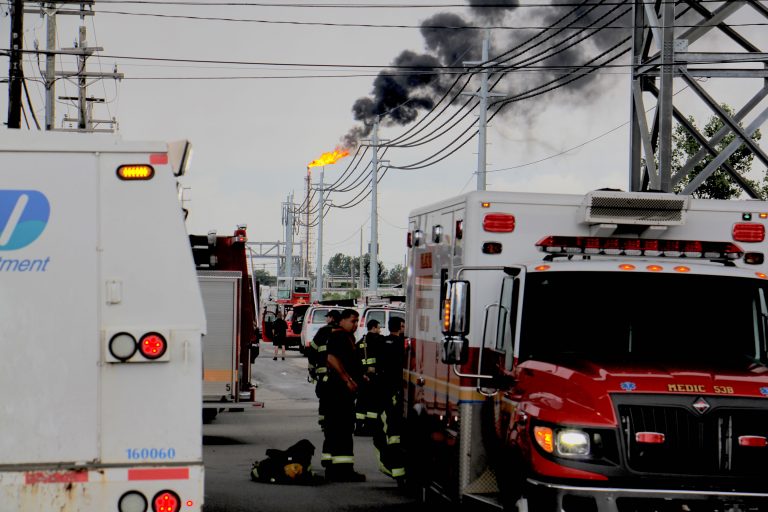 At the scene from a fire staging area under the Platt Bridge, a flare can be seen burned off fuel   (Emma Lee/WHYY)