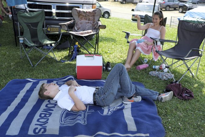 Hayden Miller-Schaeffer (left) catches a grape thrown by Sopia Kulp (right) as they rest between performances of the Miller Family Hoedown. (Matt Smith for WHYY)