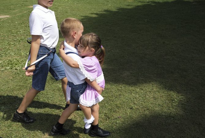 Blaik Losito (left) carries his sister Ava Losito as they leave the staging area following a performance of the Miller Family Hoedown. (Matt Smith for WHYY)