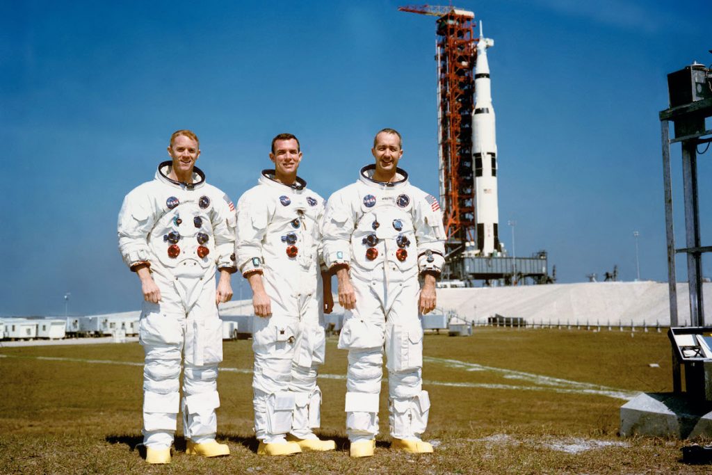 Portrait – Apollo 9 These three astronauts are the prime crew of the Apollo 9 Earth-orbital space mission. Left to right, are Russell L. Schweickart, lunar module pilot; David R. Scott, command module pilot; and James A. McDivitt, commander. In the right background is the Apollo 9 space vehicle on Pad A, Launch Complex 39, Kennedy Space Center (KSC). They are pausing momentarily during training for their scheduled 10-day mission. (NASA)